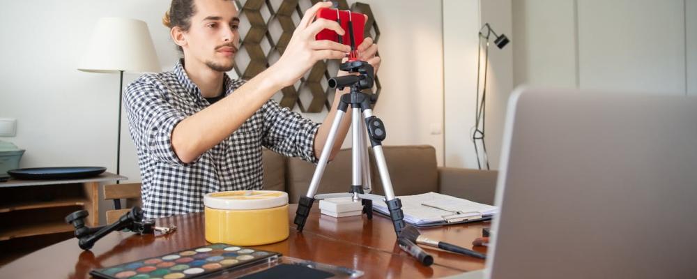 Guy using a phone on a tripod to record a video